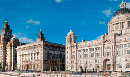 Two large buildings at the Pier Head. There is a cloudy blue sky.