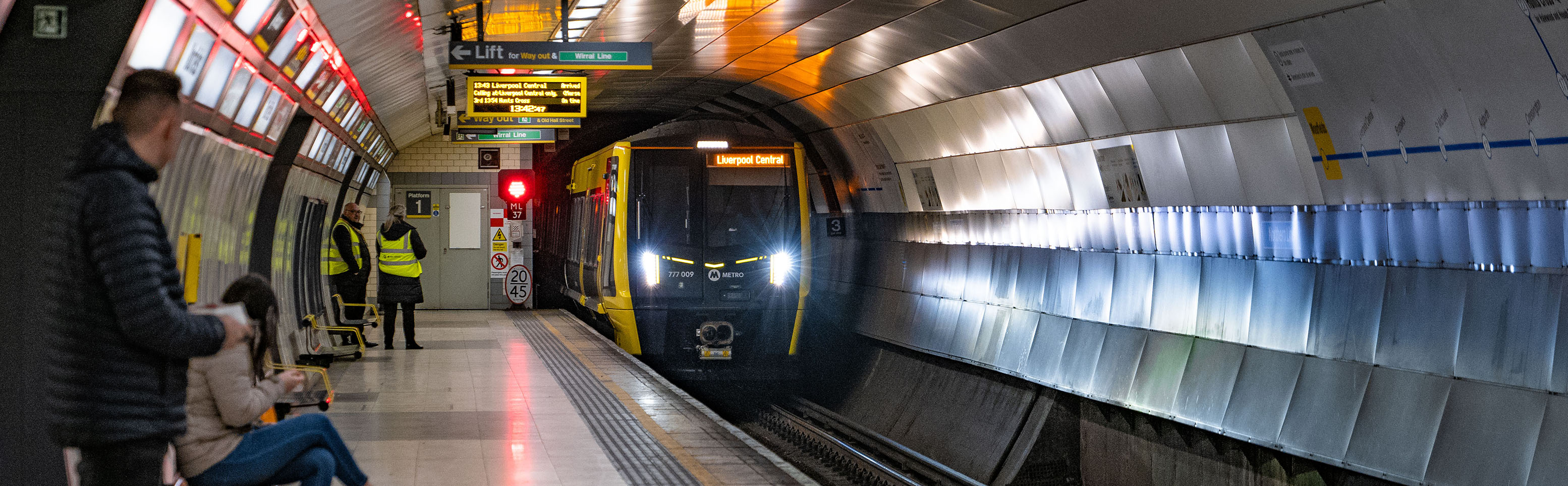 A 777 train approaching a platform at an underground station. 
