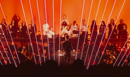 Orchestra on stage with flashing lights at a night time concert