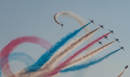 A group of planes with coloured smoke flying in the sky